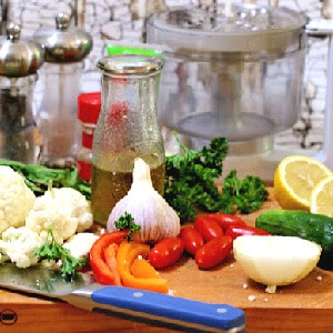 Caulilfower and other fresh vegetables are laid on a cutting board.