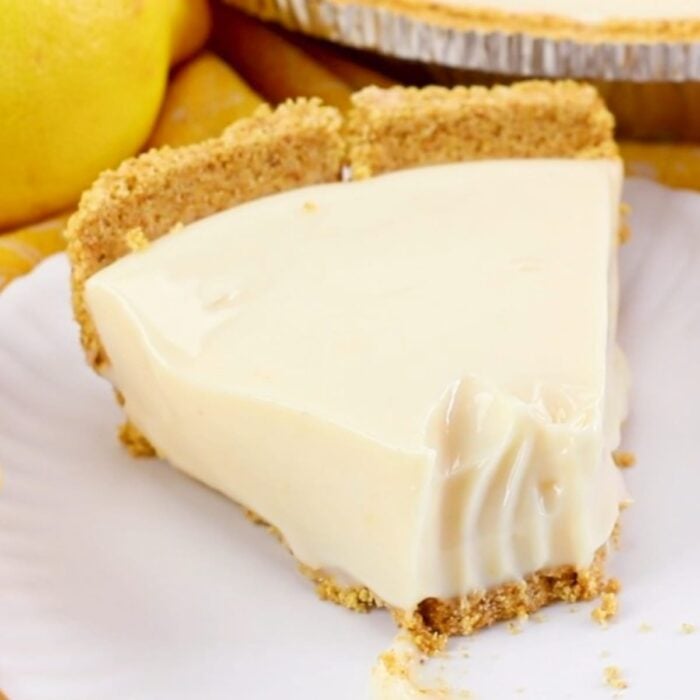 Closeup of a slice of lemon pie with a bite taken out of it for social media shares.