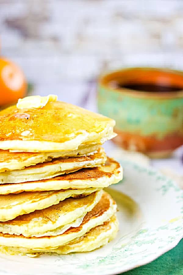 Butter melting over the top of a stack of pancakes