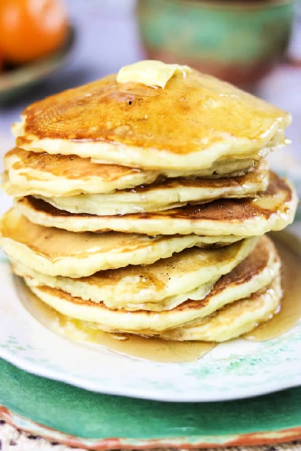 Closeup of pancakes with syrup dripping down the side.