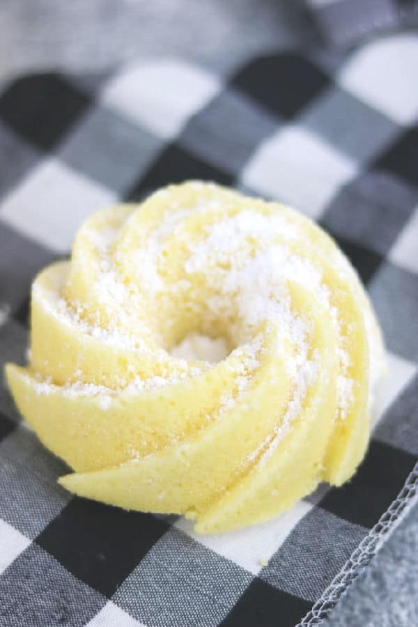 close up of a lemon chardonnay pound cake on a black and white checked napkin