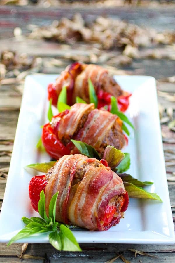 Three stuffed peppers on a serving platter.