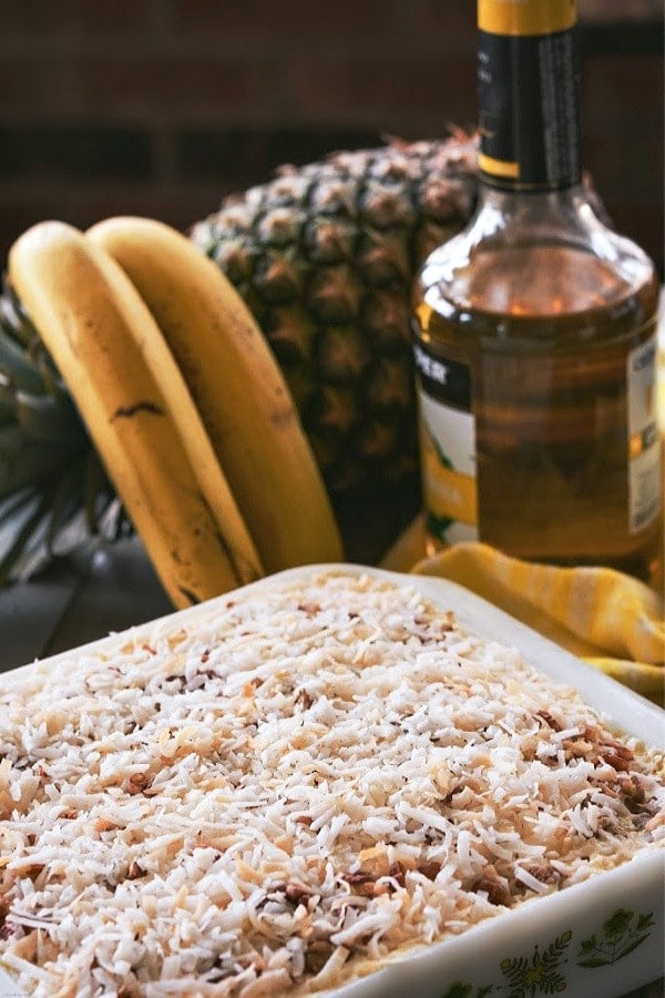 Coconut pecan topped cake in a square glass baking dish.