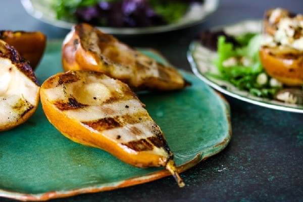 Pears with grill marks on a green platter.