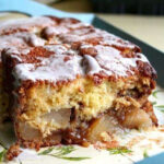 A loaf of apple fritter bread sliced to show the tender, gooey interior.