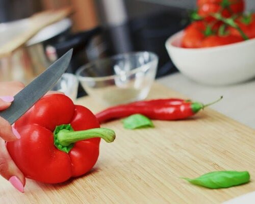 A red bell pepper being sliced