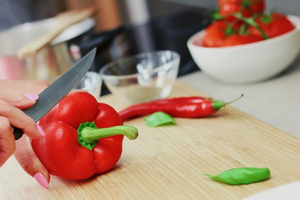 A red bell pepper being sliced