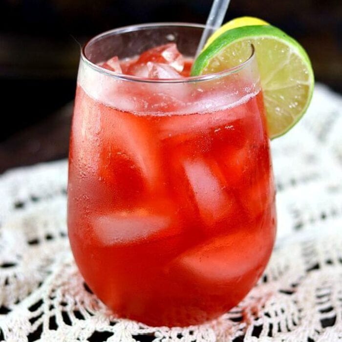 Closeup of a bright red cocktail in a clear glass.