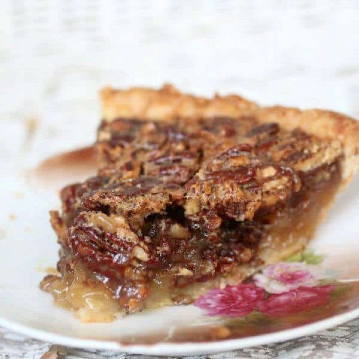 Close up of a slice of old fashioned southern pecan pie with the filling running out of the sides.
