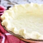 unbaked pie crust in a glass pie pan.
