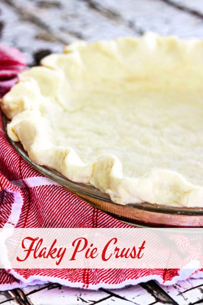 unbaked pie crust in a pie pan on a red and white tea towel. Title text overlay "Flaky Pie Crust "
