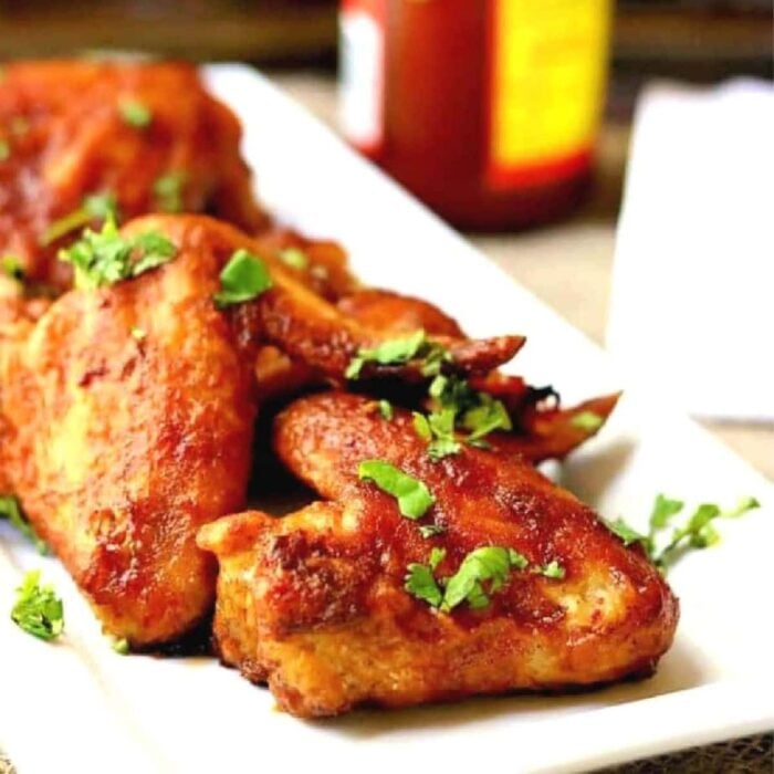 Crispy baked chicken wings on a white plate.