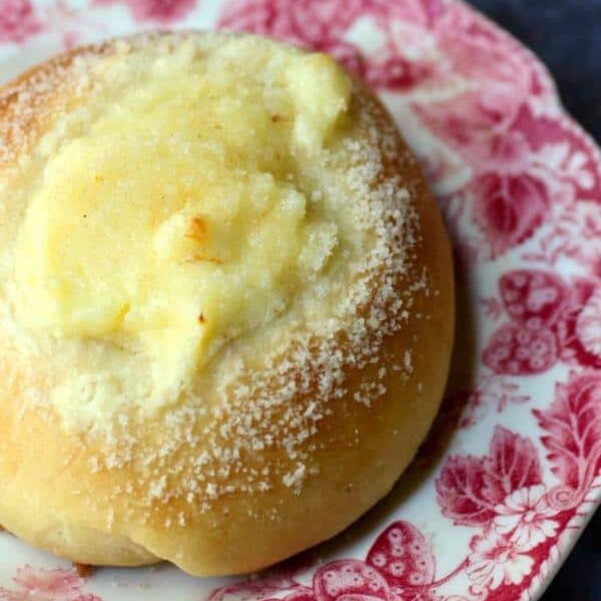 Cream cheese kolache on a red and white plate.