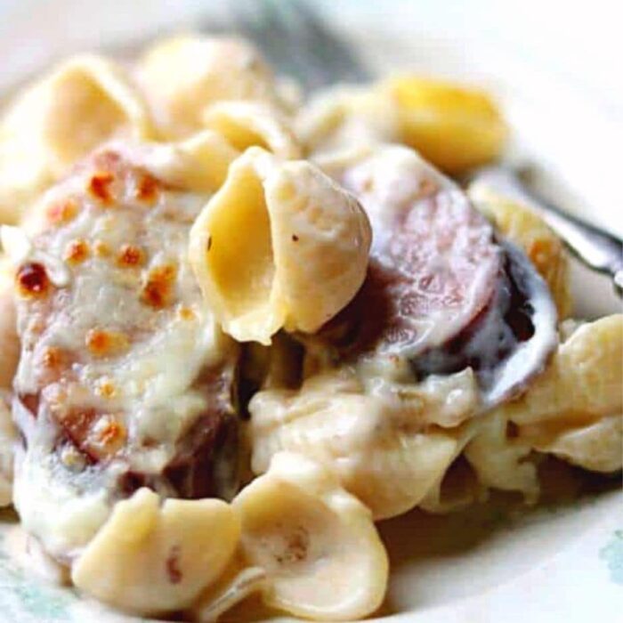 Closeup of smoked sausage alfredo skillet dinner showing pasta in a creamy sauce.