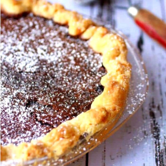 close up of chocolate chess pie waiting to be sliced.