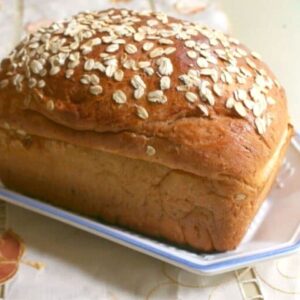 Uncut loaf of honey oatmeal bread showing the finished product