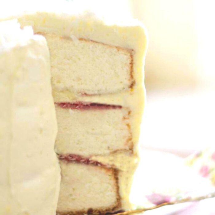 Coconut layer cake with a slice out of it to show the layers