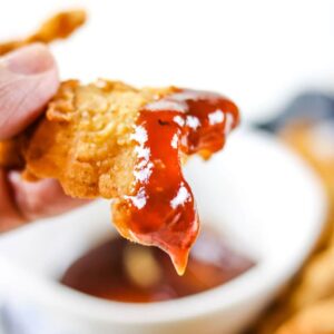 chicken strips dipped in bbq sauce.