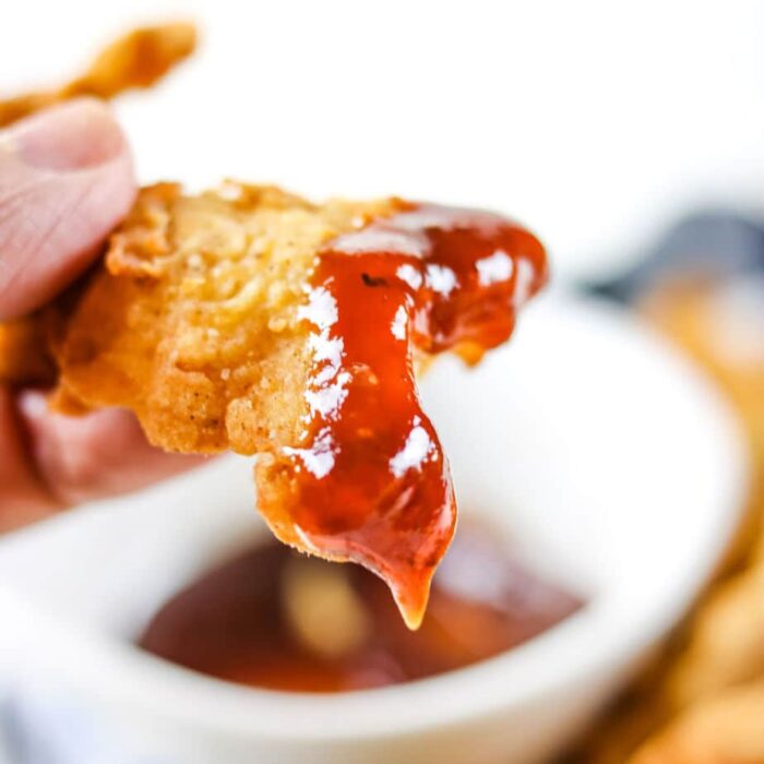 Chicken strips dipped in bbq sauce.