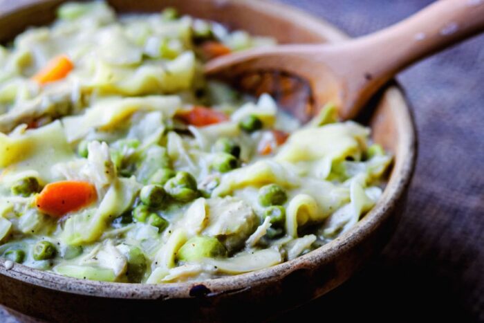 Chicken and noodles casserole with a serving spoon in the bowl.