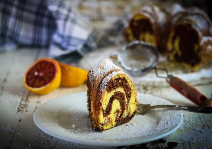 A slice of marble cake on a plate showing the chocolate and vanilla swirls.