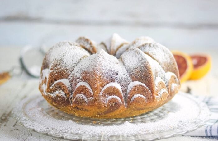 Uncut marble cake dusted with powdered sugar, showing the design.