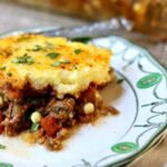 Tamale pie on a white and green plate.