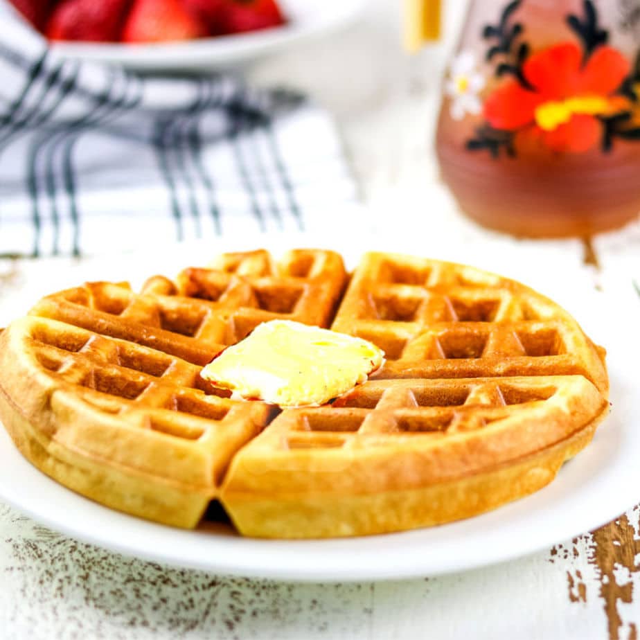 Closeup of a finished waffle with butter on top.