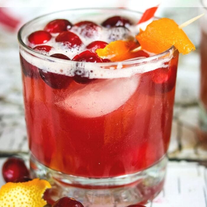 Close up of a cranberry whiskey sour in an on the rocks glass.