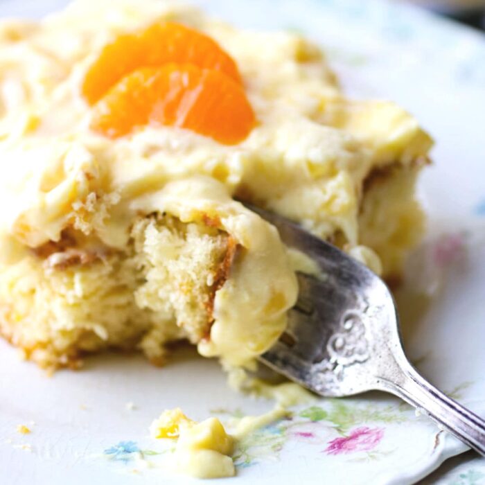 A fork cutting into a square of cake.