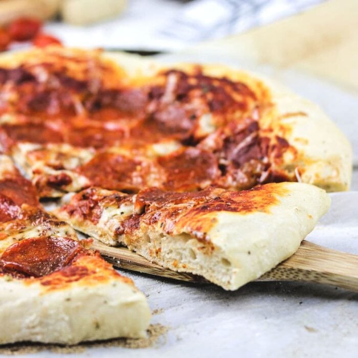 A closeup of a slice being removed from a pizza.