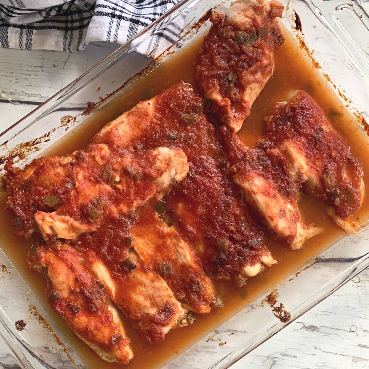 Chicken breasts in a glass baking pan.