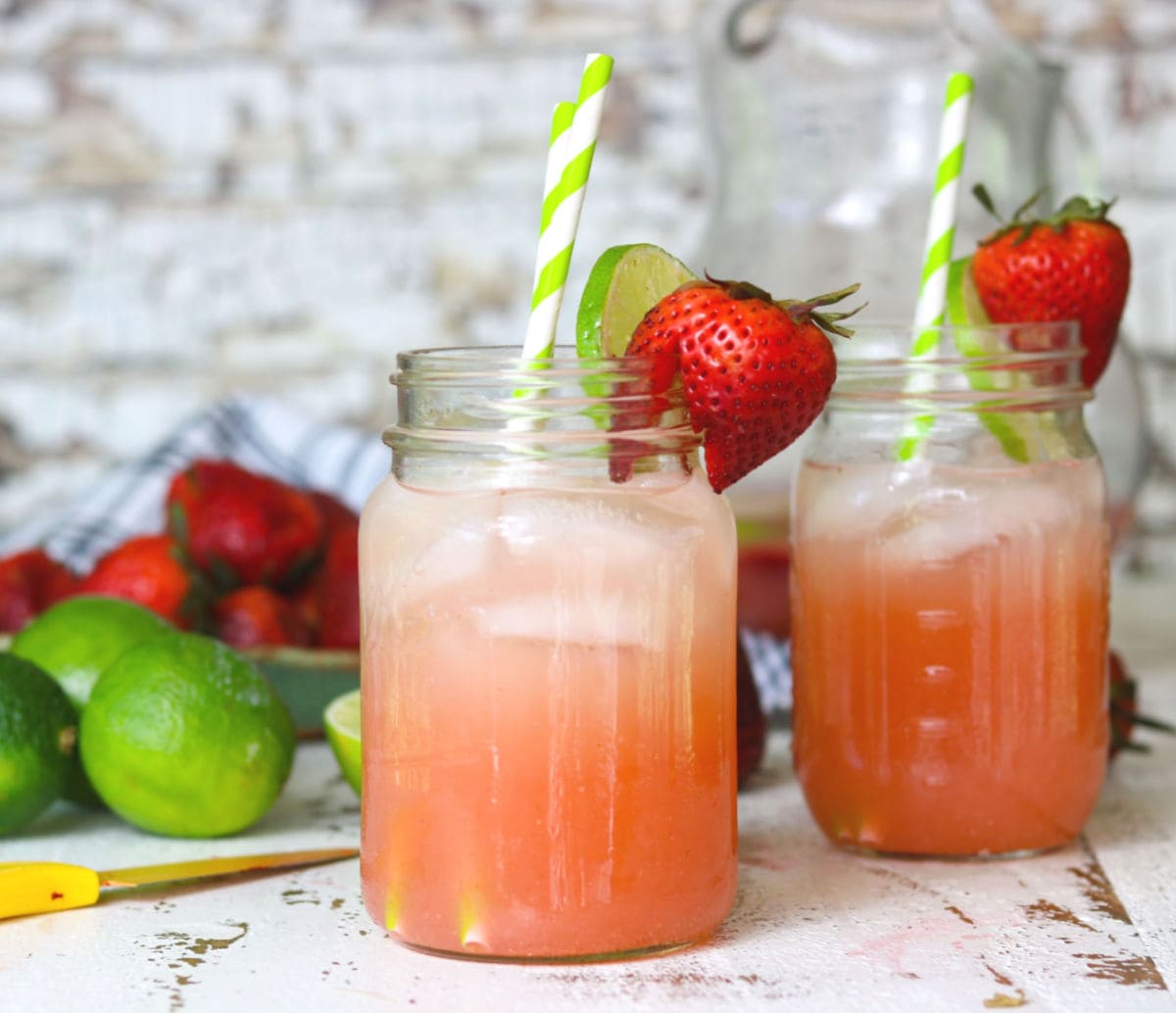 Two Mason jars of strawberry vodka lemonade ready to drink.