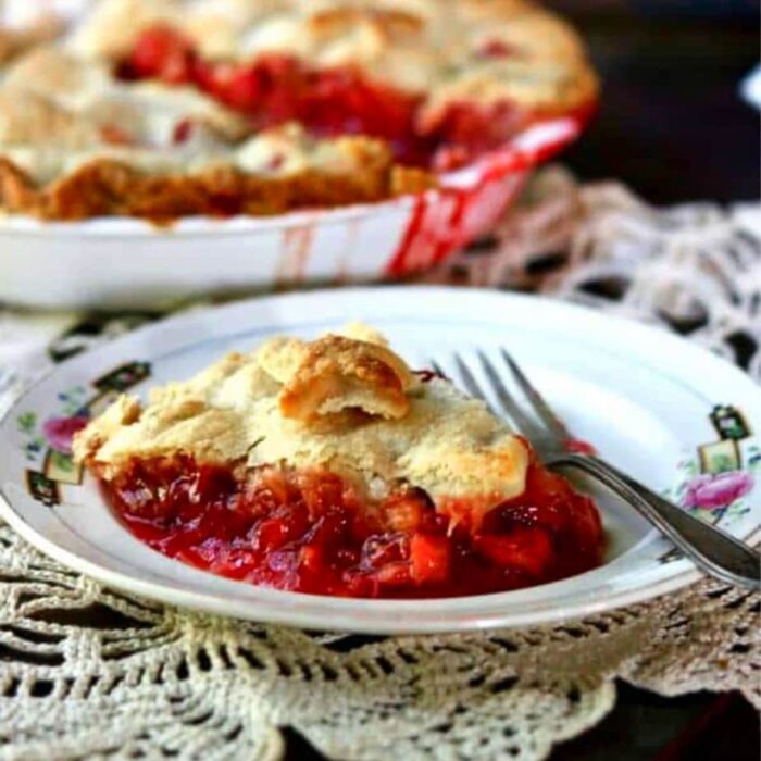 slice of strawberry pie on a plate with a fork to the side.