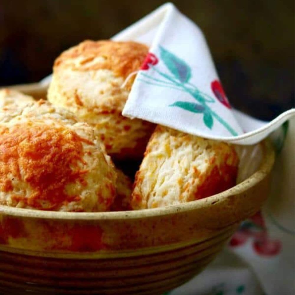 Big, flakey biscuits in a yellow ware bowl