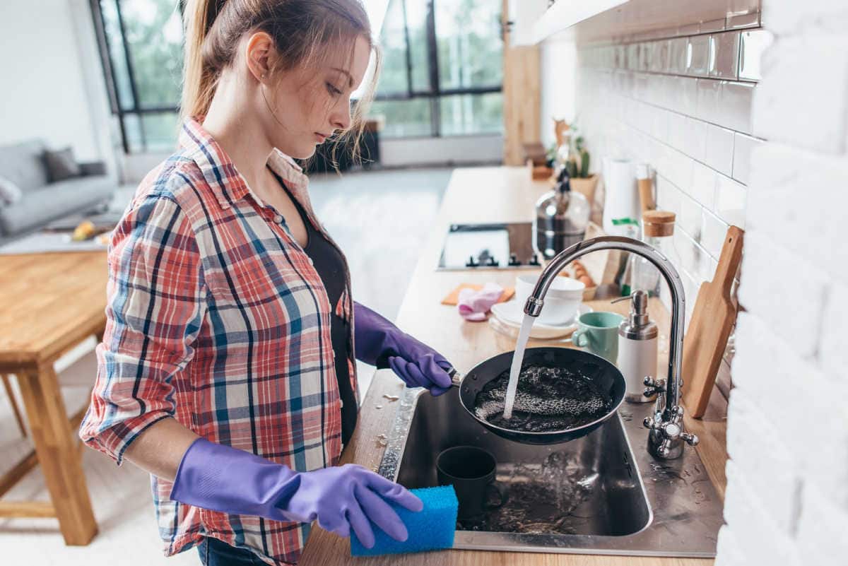 A woman cleaning up the kitchen.