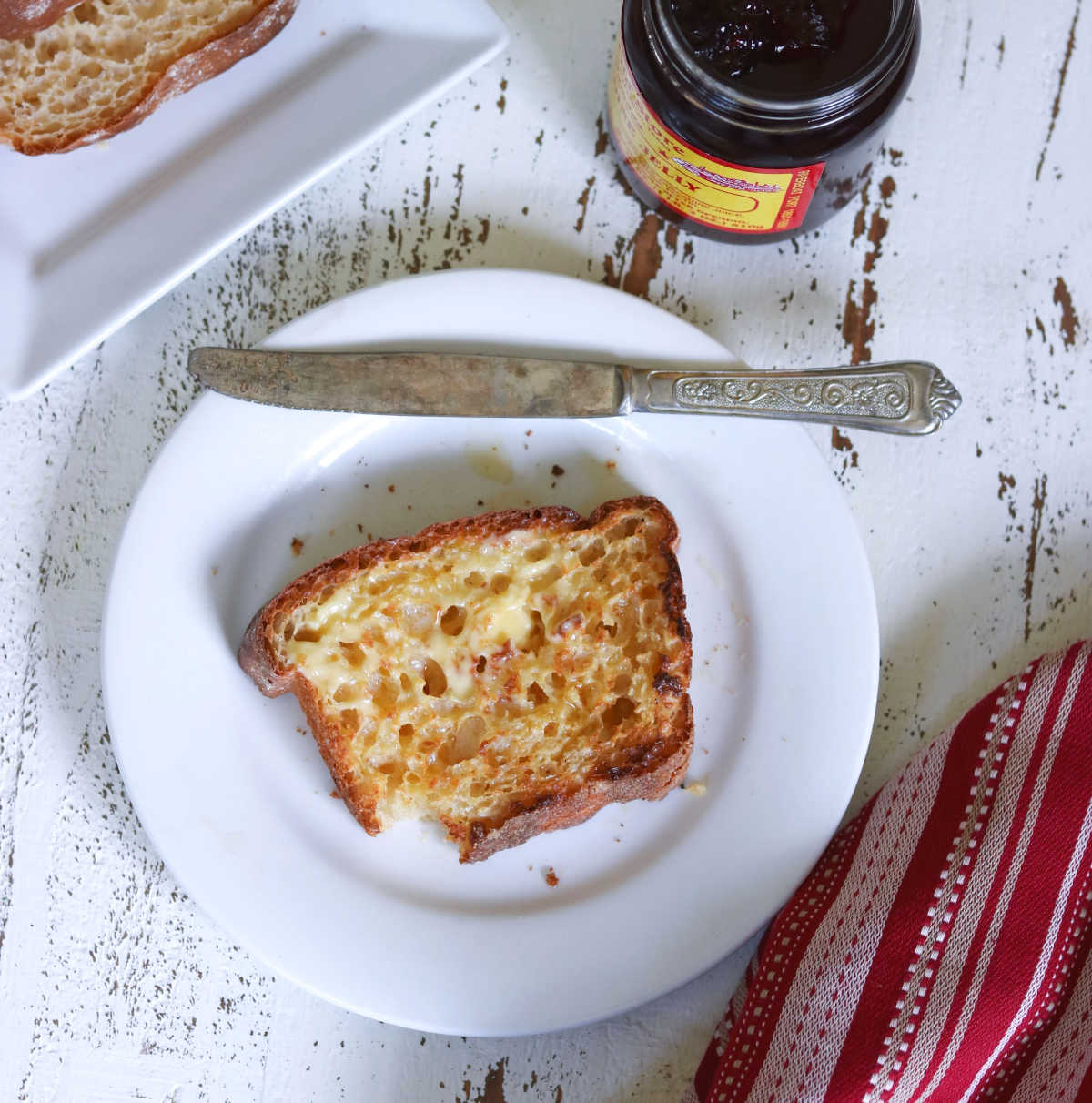 Slice of toasted english muffin bread on a white plate