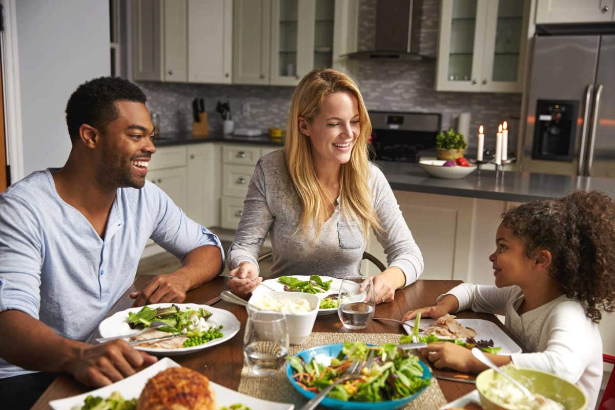 A biracial enjoying a family dinner.