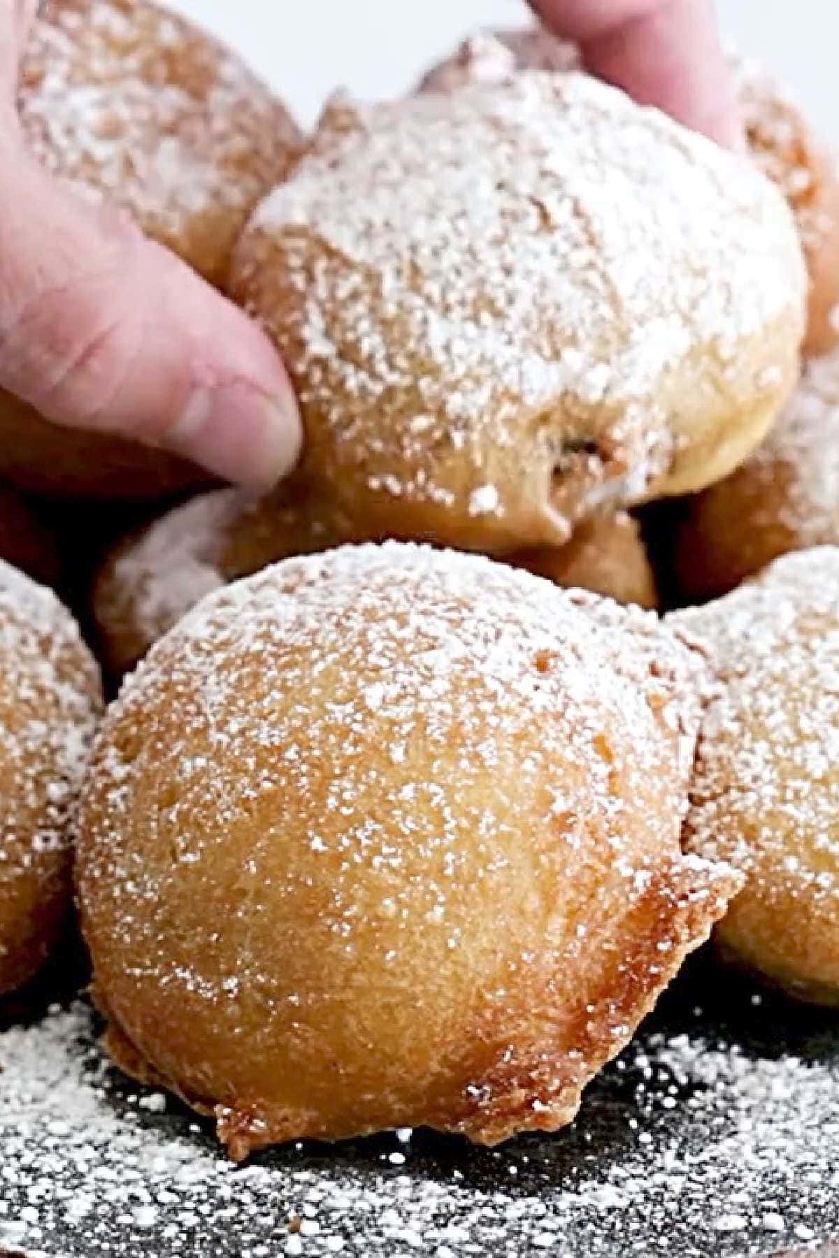 A hand removing a deep fried Oreo from the plate.