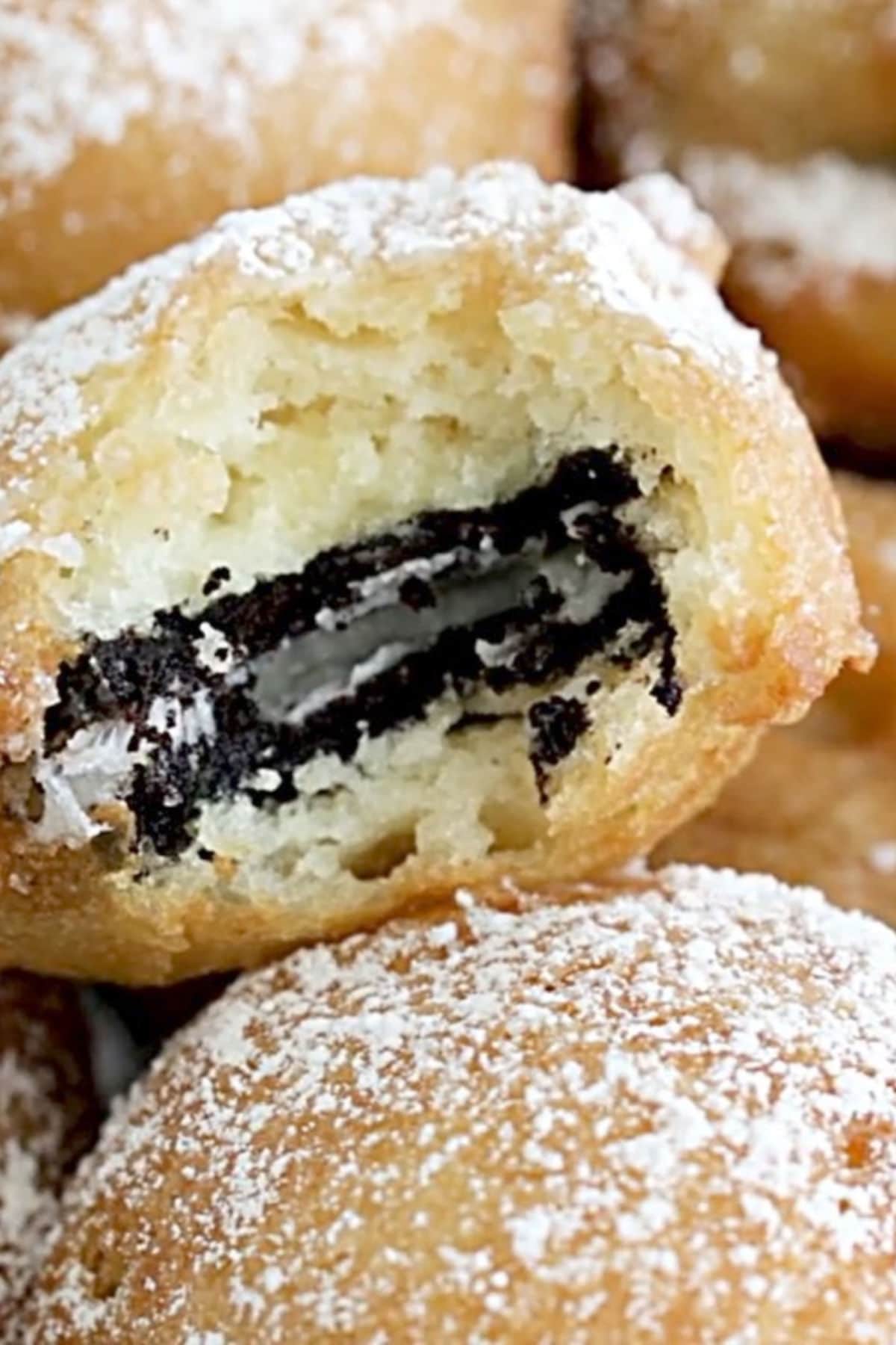 A closeup of a deep-fried Oreo with a bite taken out of it.