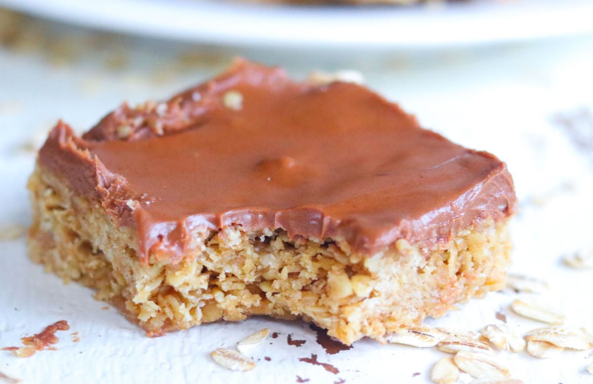 One of the Oh Henry bars with a bite taken out of it showing layers of cookie and chocolate.