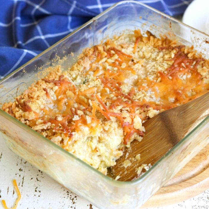 Scoop being removed from squash casserole to show inside texture.