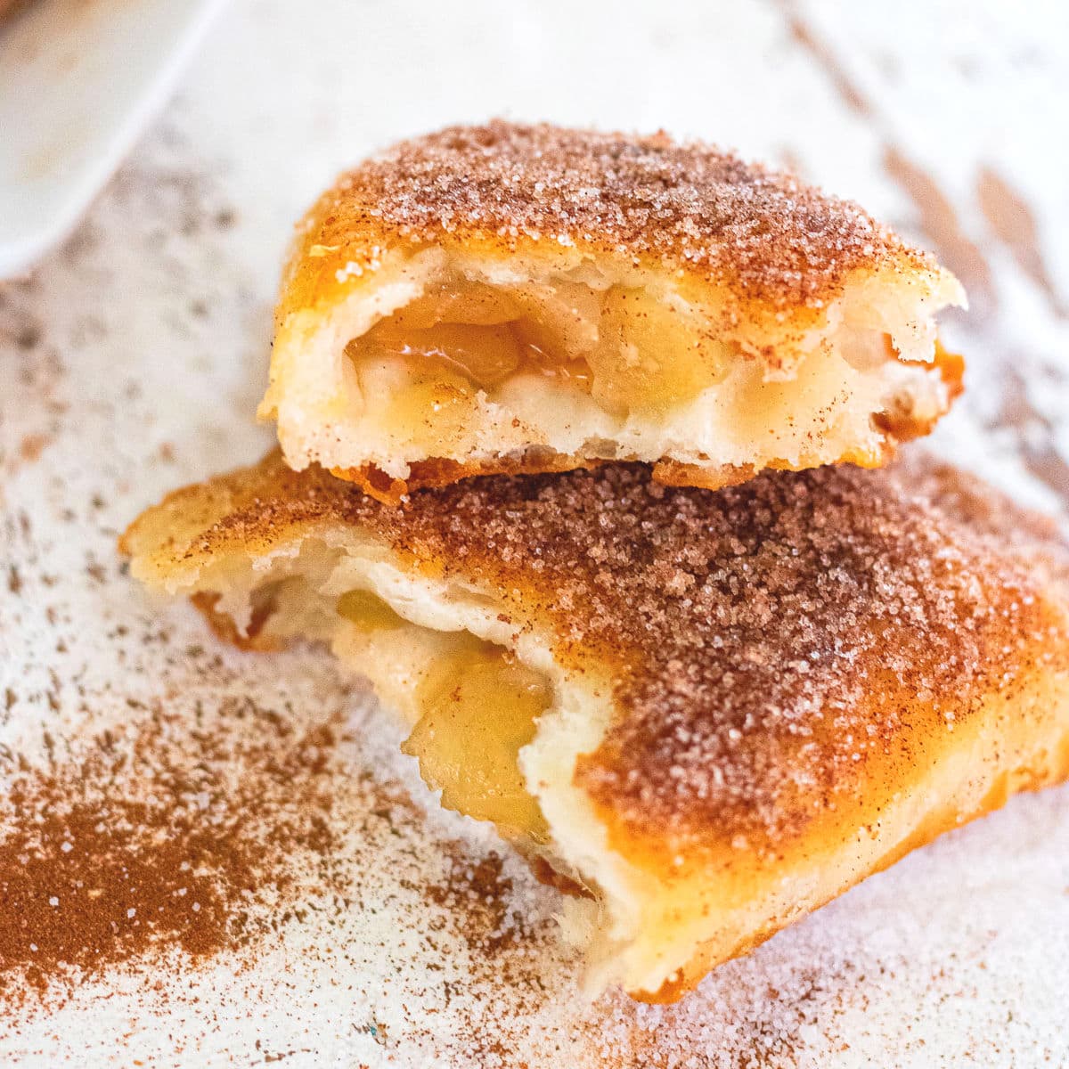 Fried pies cut in half to show the apple filling inside.