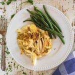 Serving of chicken and dressing with green beans on the side.