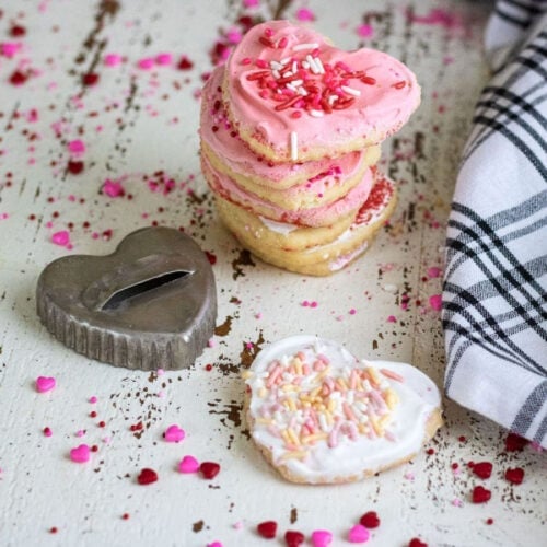 Heart shaped sugar cookies with frosting on a table.