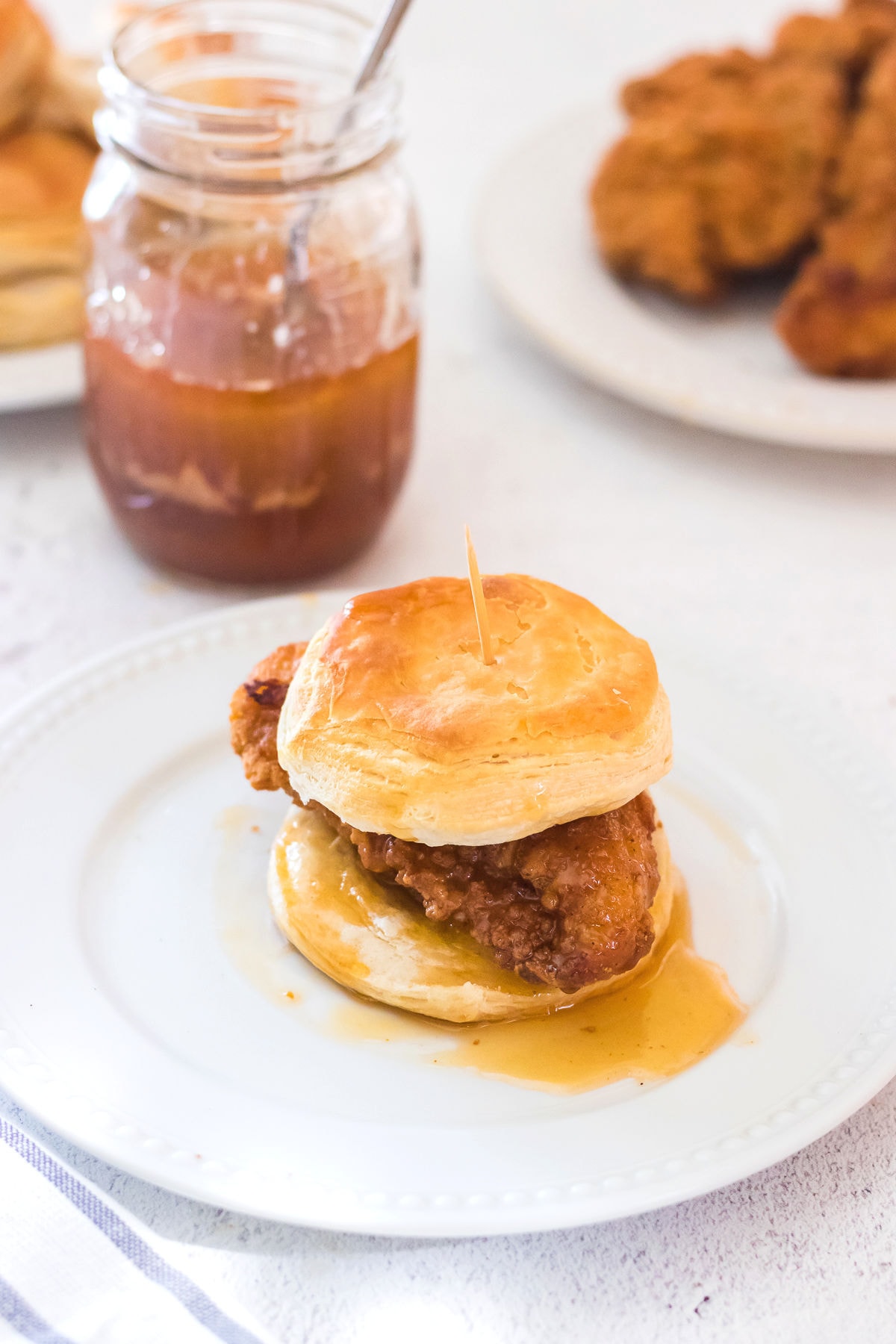 Finished chicken biscuit on a plate with ingredients in the background.