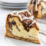 Close up of a slice of cinnamon roll cheesecake showing the layers.
