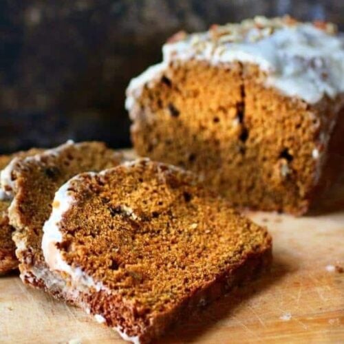 Slices of pumpkin spice bread on a cutting board.