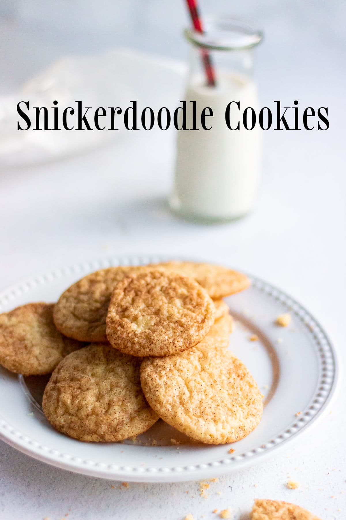 A plate of snickerdoodle cookies with a glass of milk.