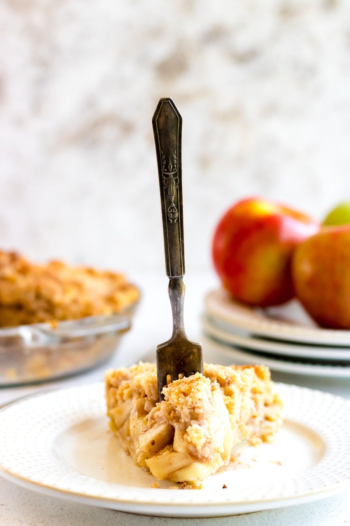 A slice of homemade apple pie with a fork in it.